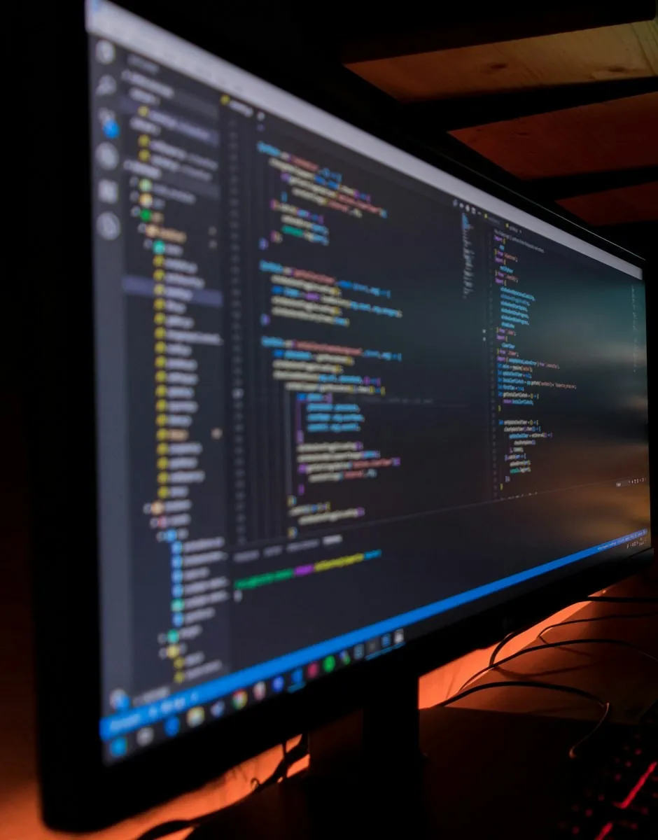 Two monitors showing source code in a development environment